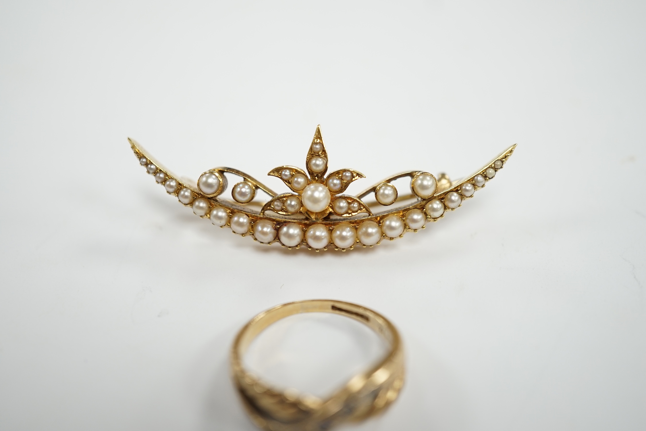 A yellow metal and seed pearl cluster set crescent shaped brooch, 48mm and a 9ct gold and cubic zirconia set ring, gross weight 10 grams.